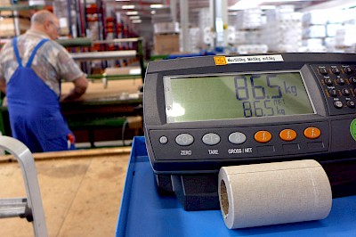 Digitalisierung in der Produktion: Die Waage zeigt an, wie viel Ware der Mitarbeiter schon produziert hat. Die Zahl wird auch auf einem großen Display in der Halle angezeigt.